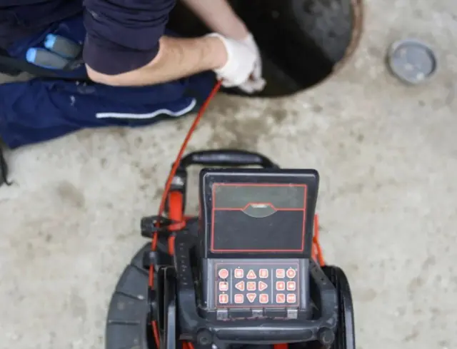 Septic line camera inspection monitor in use at the tank opening