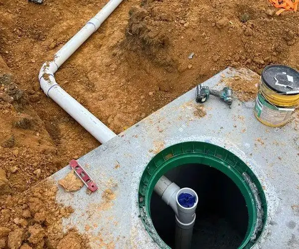 Top of a septic tank showing the riser and pipe connection