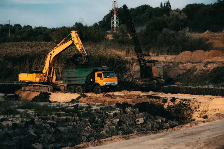 Excavator loading a dump truck at a commercial excavation site