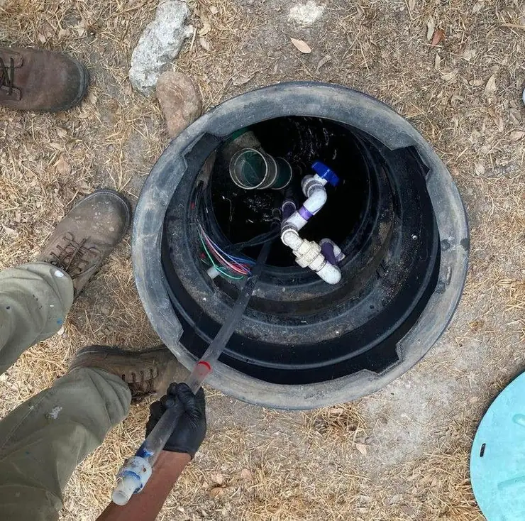 Pump and plumbing visible inside a septic riser (effluent glossary guide)