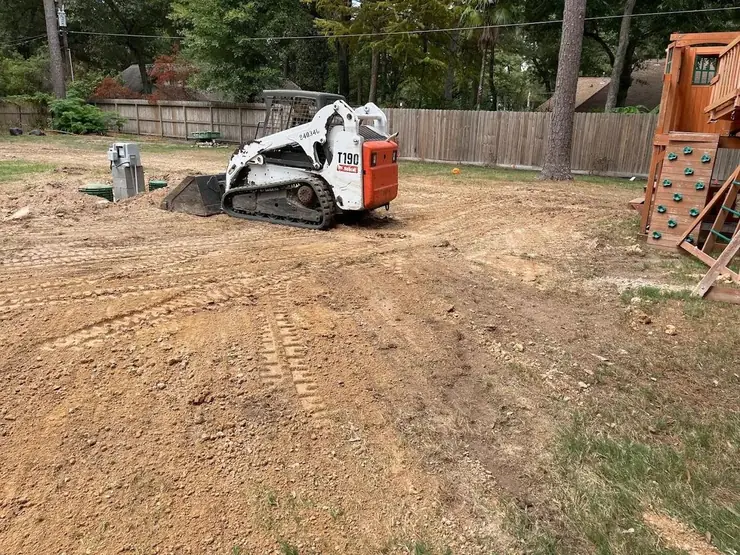 Skid steer grading a yard for site preparation