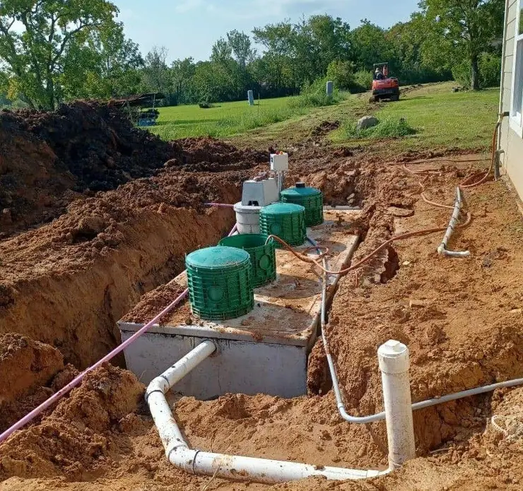 Septic tank installation with risers and plumbing