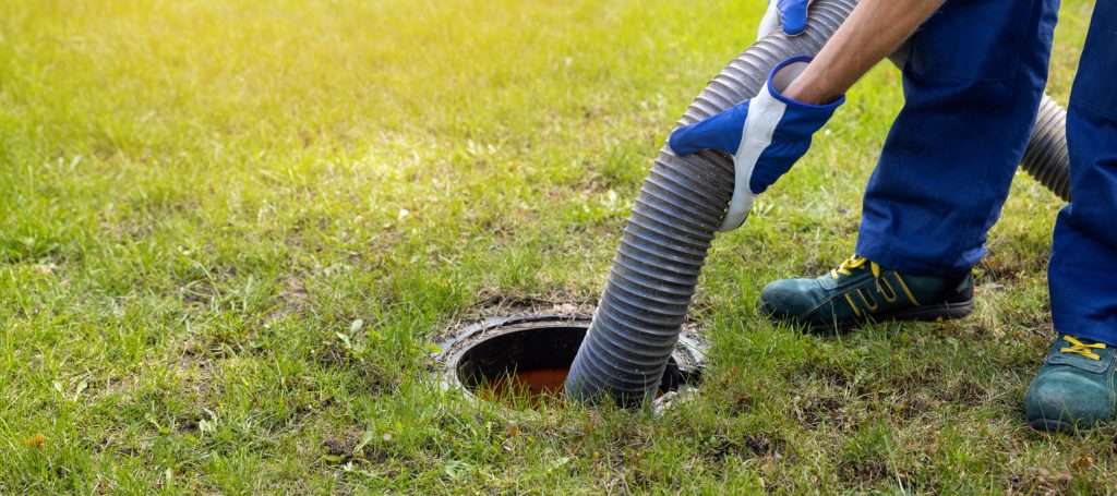 man pumping out house septic tank. drain and sewage cleaning service. copy space